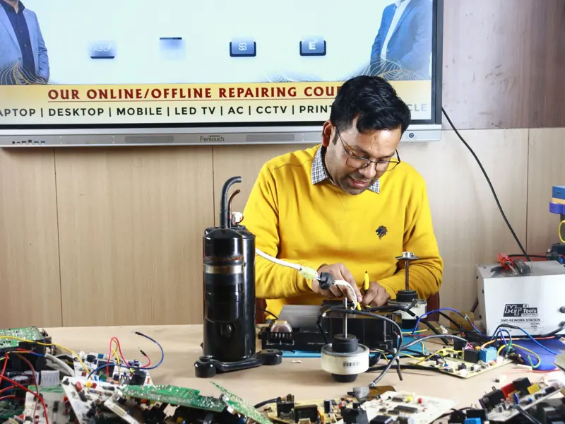 Technician engaged in AC repair at a New Delhi workshop. Indoor learning session.