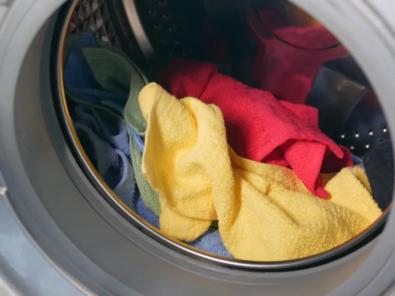 Vibrant close-up of multicolored towels inside a washing machine, ready for a wash.