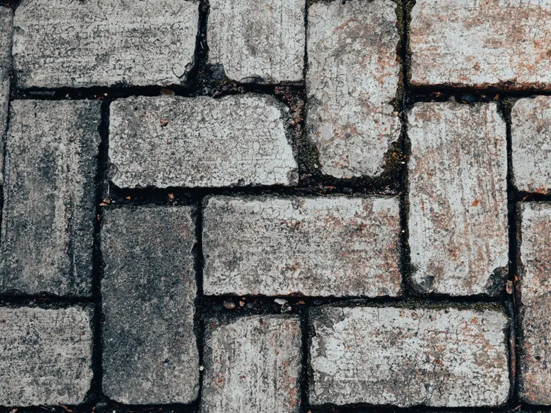 Detailed image of gray stone paving blocks with earthy tones showcasing rustic texture.