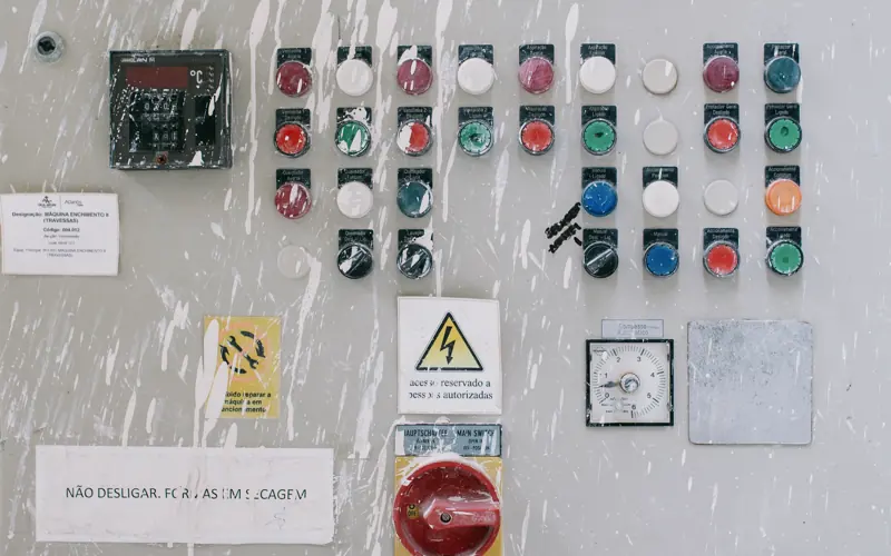 Close-up of an industrial control panel with colorful warning buttons and switches.