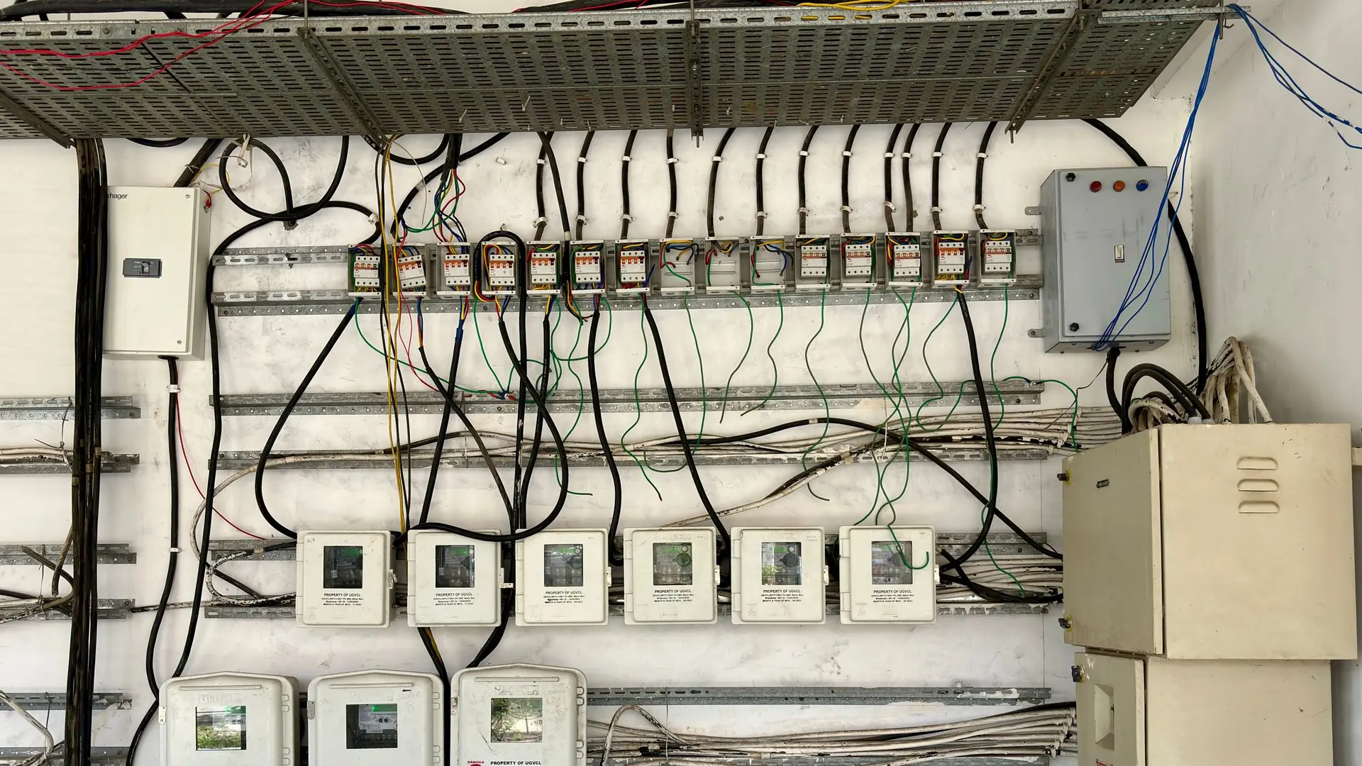 Complex network of electrical wiring and control panels in an industrial setting.