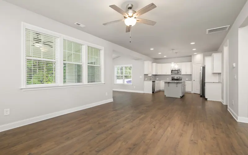 Spacious open-concept kitchen and living room with hardwood floors and large windows.