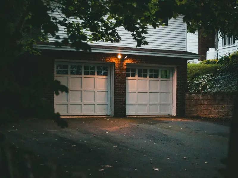 Warm evening view of a suburban garage with soft lighting creating a cozy atmosphere.