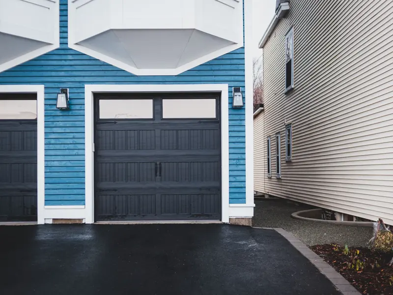 Exterior of contemporary residential building with wooden door and walls paneled blue and lights