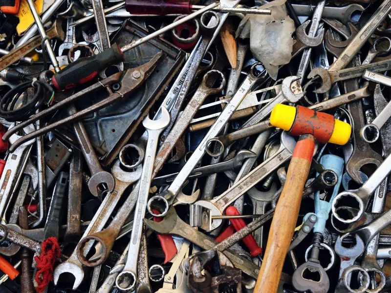 Close-up view of various tools including wrenches and a hammer, providing a cluttered yet organized look.