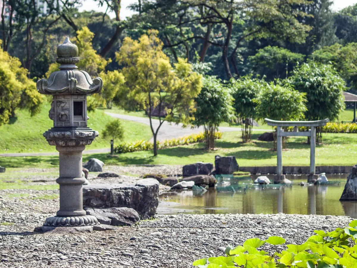 Tranquil view of a Japanese garden featuring a stone lantern and pond.