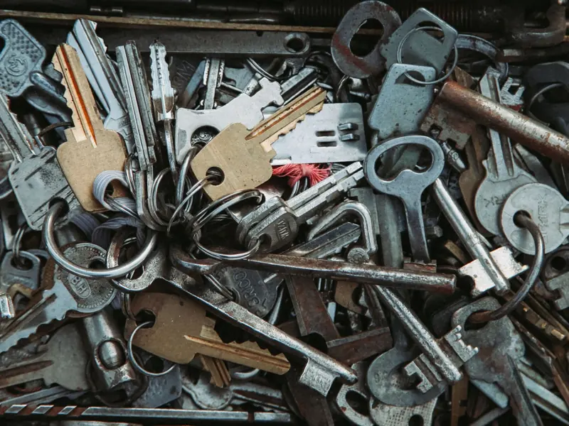 Assorted rusty metal keys piled together, showcasing a vintage and industrial feel.
