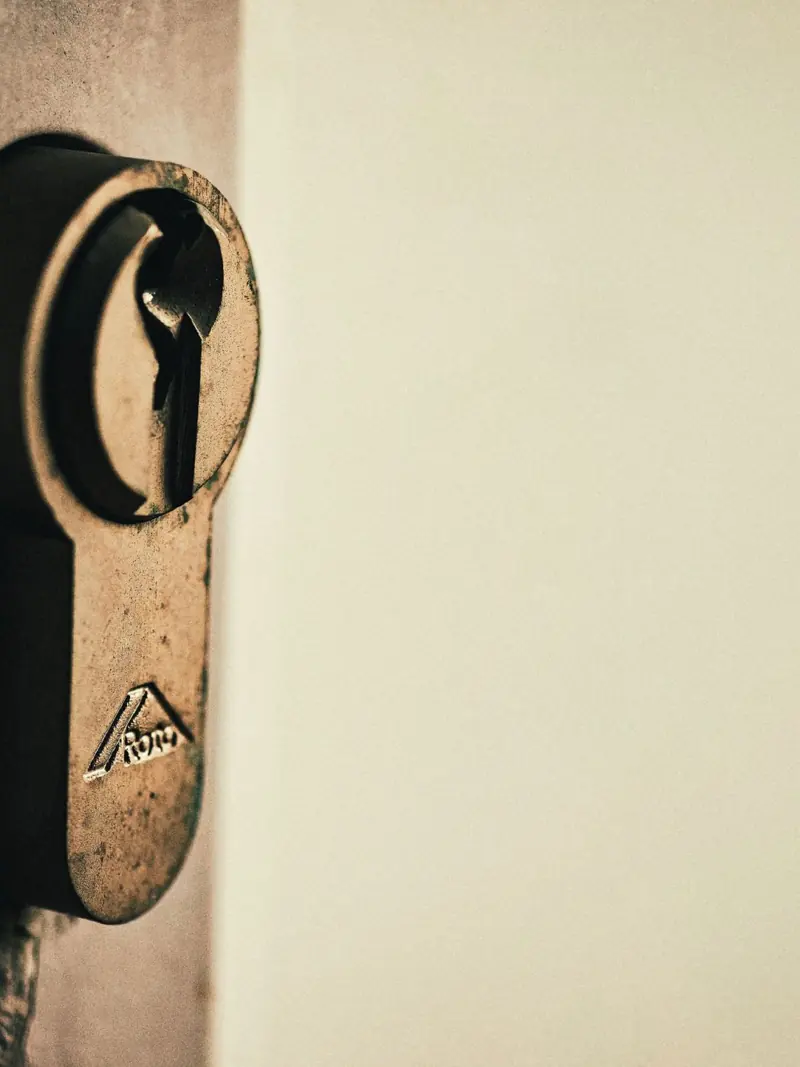 Close-up of vintage keyhole on a weathered wooden door, capturing rustic charm.