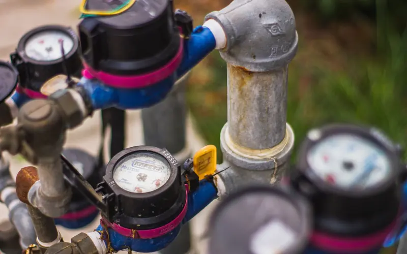 Detailed image of industrial water pressure gauges and pipes in an outdoor setting.