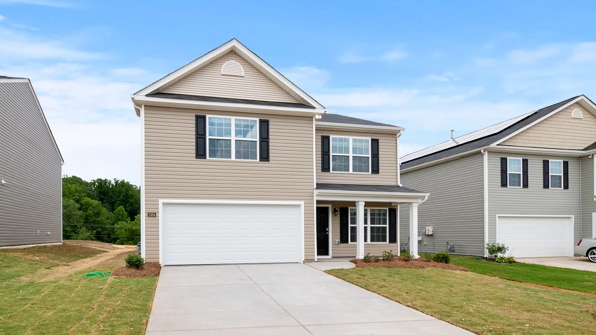 Contemporary two-story suburban home with a spacious driveway and lawn.