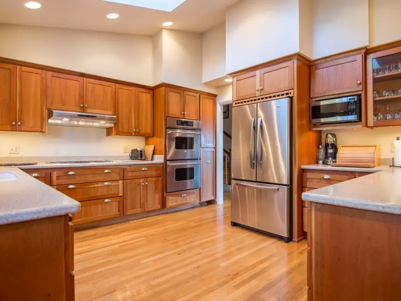 Bright kitchen with wooden cabinets and stainless steel appliances.