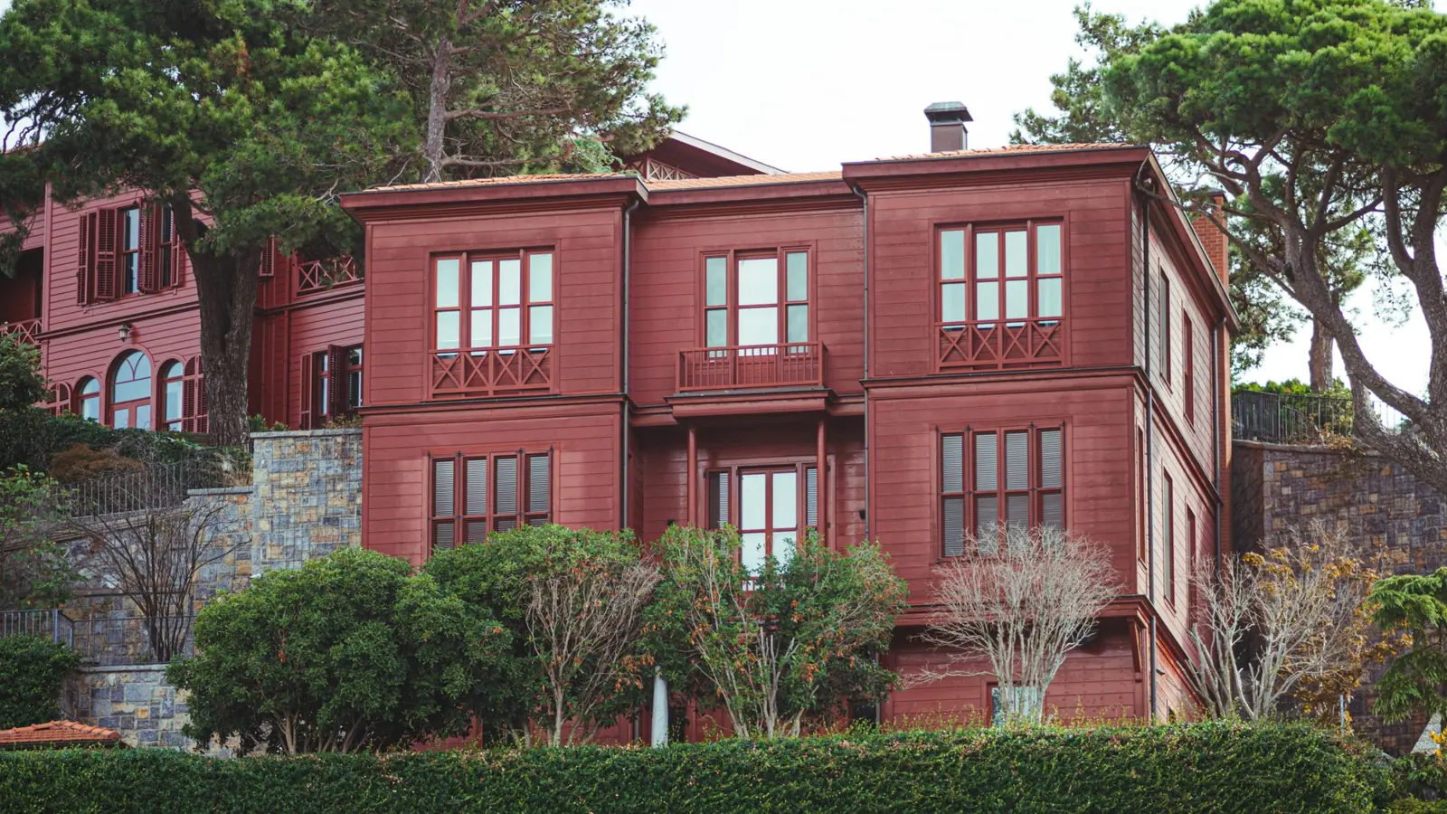 A picturesque red house surrounded by greenery in an urban setting in Istanbul, Turkey.