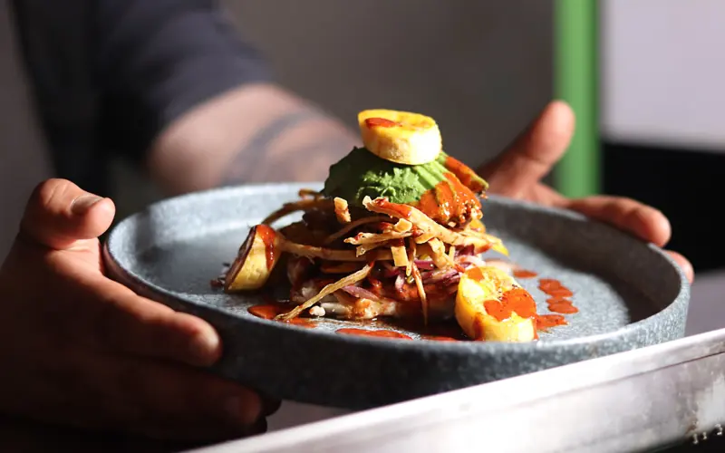A delicious gourmet meal featuring plantains and sauce, elegantly plated and ready to serve.