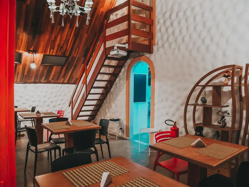 A modern restaurant interior with wooden architecture, inviting decor, and stylish furnishings.