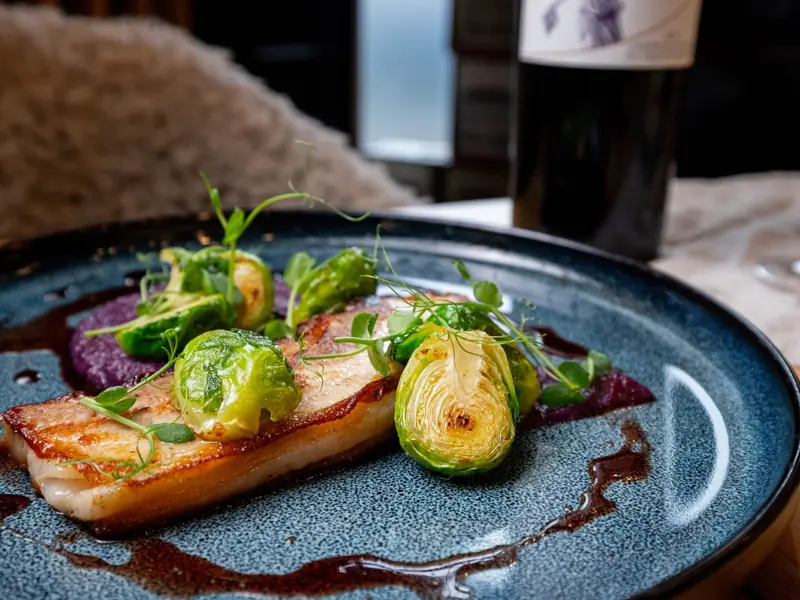Delicious pork belly with Brussels sprouts and sauce, served in Bratislava, Slovakia.