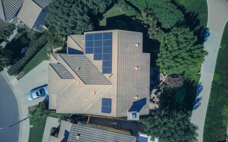 Top-down aerial view of a house with solar panels, showcasing modern renewable energy solutions.