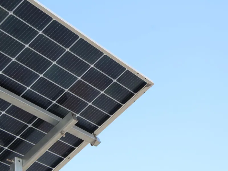 A modern solar panel with a clear blue sky background, highlighting renewable energy.